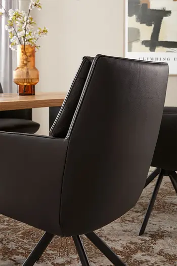 Rückenlehne eines hochwertigen Esszimmerstuhls in schwarzem Leder.