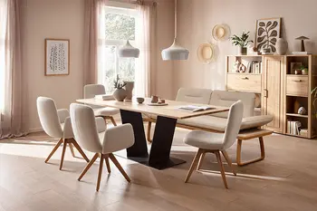 Helles Esszimmer mit Holzparkett, großem Massivholzesstisch, Sideboard und beigen Esszimmerstühlen mit passender Sitzbank.