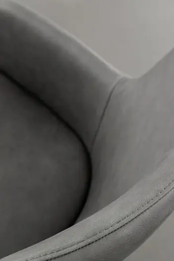 Sitzfläche und Armlehnen eines bequem gepolsterten grauen Esszimmerstuhls mit Lederbezug.