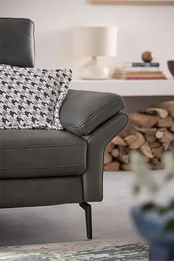 Armlehne einer grauen Design Leder Garnitur.