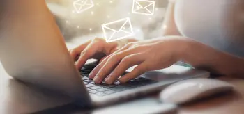 Frau am Laptop liest E-Mails.