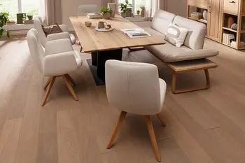 Natürlich eingerichtetes Esszimmer mit Tisch aus Wildeiche, Sitzbank und passenden Stühlen mit beigem Stoffbezug.