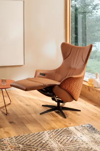 Oranger Leder Relaxsessel, der außen mit Stoff bezogen ist mit ausgezogener Fussstütze.