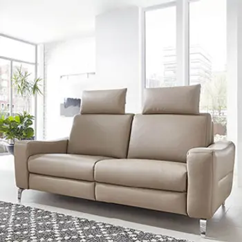 Beiges Ledersofa mit Kopfstützen.