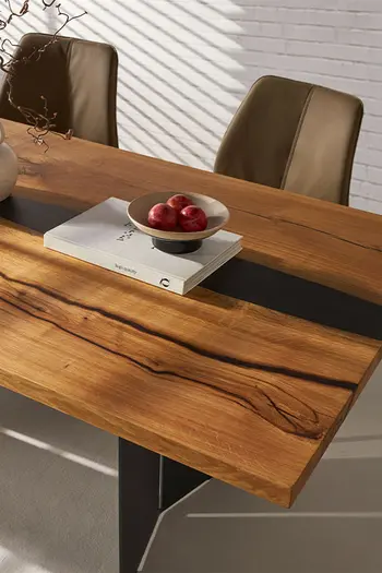 Tischplatte eines modernen Esstisches aus Massivholz, mit Akzenten aus Epoxidharz.