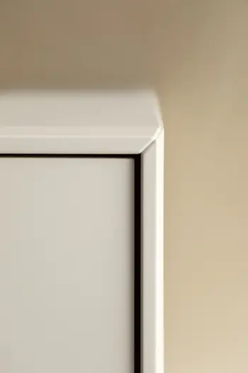 Ecke eines weißen Sideboards.