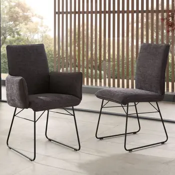 Grauer Armlehnstuhl mit schwarzem Metallgestell neben einem grauen Esszimmerstuhl mit schwarzem Metallgestell.