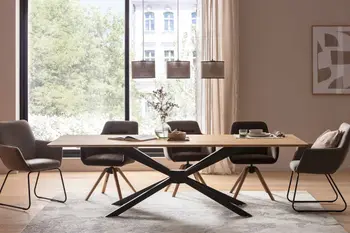 Ein großer Esstisch aus Holz an dem fünf moderne Schalenstühle mit Holz- und Metallgestellen stehen mit Bezügen in grau.