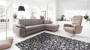 Braunes Ecksofa mit breiter Sitzfläche und ein hellbrauner Leder Relaxsessel mit silbernem Sternfuß.
