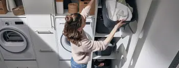 Frau verstaut Wäsche in Hauswirschaftsruam