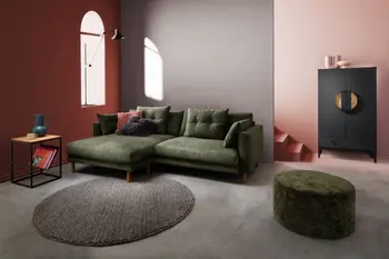 Grünes Ecksofa mit passendem Hocker in modernem Wohnzimmer mit roter Akzentwand.