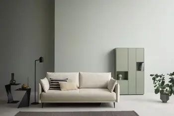 Beiges Zweisitzer Sofa in einem modernen Wohnzimmer mit schwarzen Beistelltischen auf denen Vasen stehen und einer schwarzen Lampe.