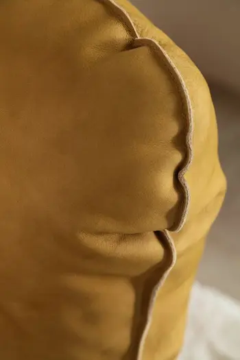 Detailansicht der Naht der Armlehne eines gelben Relaxsessels.