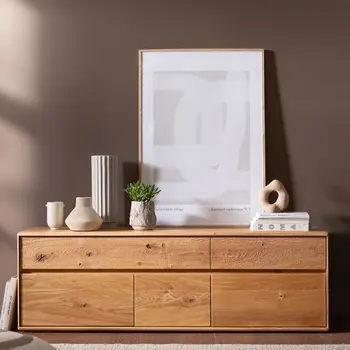 Lowboard aus Massivholz dekoriert mit Vasen, einem großen Bild und einer Pflanze.