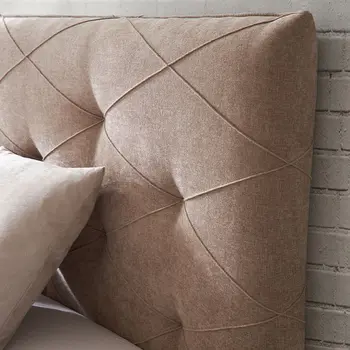 Gestepptes Kopfteil eines beigen Design Polsterbetts.