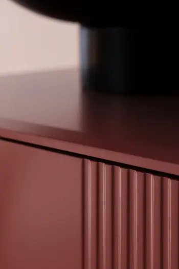 Front einer modernen Vitrine in rotem Lack mit rillen.