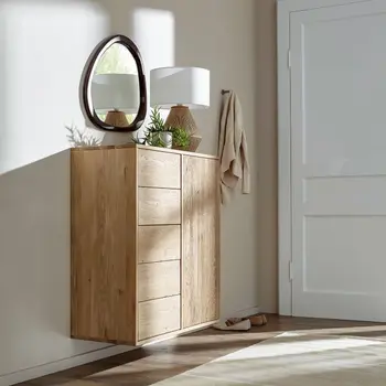 Hängende Kommode einer Garderobe, die auf der Linken Seite Schubladen hat und rechts eine Tür, dekoriert mit einer Lampe, Pflanze und darüber hängt ein organischer Spiegel mit schwarzem Rahmen.