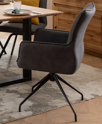 Grauer Armlehnstuhl mit schwarzem Drehgehstell.