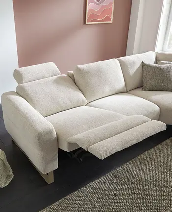 Beiges Sofa mit ausgeklappter Relaxfunktion zum Entspannen.