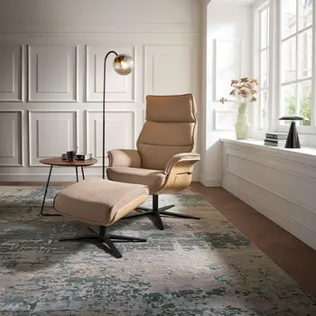 Beiger Design Relaxsessel mit Holzschale an den Armlehnen in einer Altbauwohnung.