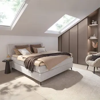 Elegantes Schlafzimmer mit hellgrauem Boxspringbett.