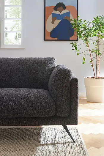 Klappbare Armlehne eines dunkelgrauen Sofas - hochgestellt.