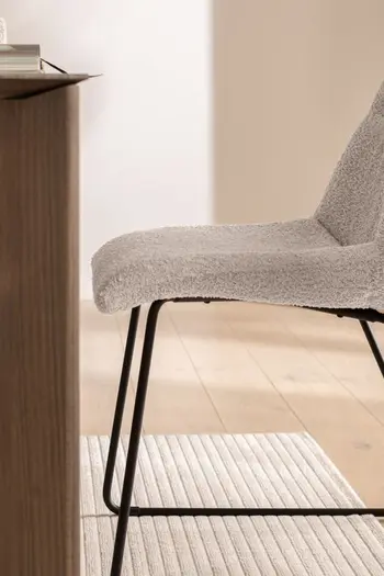 Seitenansicht eines Schalenstuhls mit grauem Bezug und einem schwarzen Metallgestell.