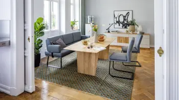Modernes Esszimmer mit einer Sitzbank mit Armlehne und dazu passenden Freischwingern in blauem Leder mit schwarzem Metallgestell.