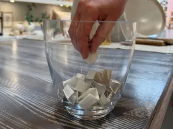Eine Hand greift in einen Lostopf