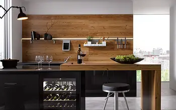 Küche mit Küchenblock in Holzoptik und Essbereich mit Hockern.&nbsp;