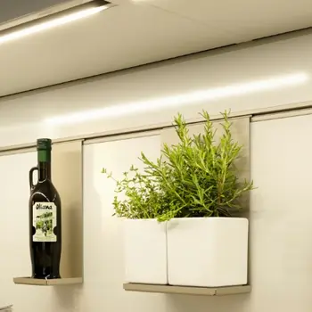 Nahaufnahme eines Hängesystems für Küchenutensilien, darüber ein beleuchteter Lichtstreifen.&nbsp;