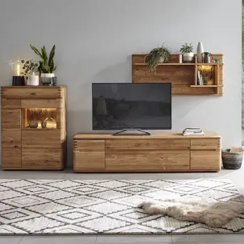 Massivholz Wohnwand dekoriert mit vielen Pflanzen und beleuchtetem Regaleinsatz beim Highboard.