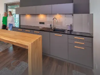 Einbauküche grau mit großzügigem Tresen und Holzgriffen