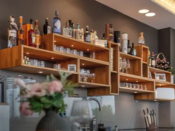 Individuelles Wandregal mit Gläsern und Flaschen in einer Bar