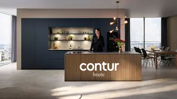Aktuelle Contur Küche mit Kücheninsel aus Holz und blauen Hochschränken neben einem Contur Esstisch mit Stühlen.