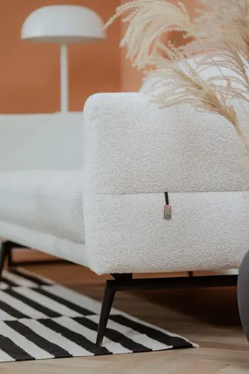 Seitenansicht eines weißen Sofas mit schwarzem Metallgestell.