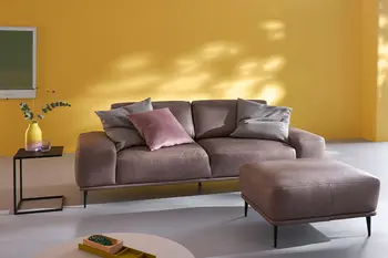 Braunes Ledersofa mit filigranen schwarzen Metallfüßen und dazu passender Hocker.