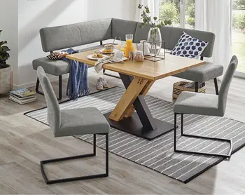 Hoelzerner Esstisch mit hellgrauen Stuehlen und Sitzbank in kompaktem Esszimmer.