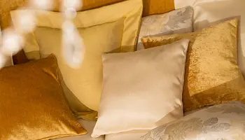 Goldene Zierkissen auf einem Bett arrangiert