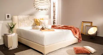 Elegantes Schlafzimmer mit Polsterbett, Deckenleuchte und Deko.