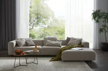 Großes beiges Design Ecksofa mit breitem Longchair in einem hellen modernen Stadthaus.