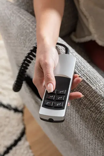 Fernbedienung eines grauen Relaxsessels.