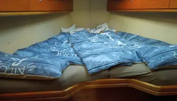 Bett mit blauer maritimer Bettwäsche im Boot