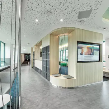 Aufenthaltsraum mit Bildschirm, Schließfächern und Sitzgelegenheiten