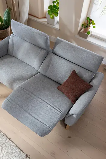 Vogelperspektive auf hellgraues 2-Sitzersofa mit Relaxfunktion in Wohnzimmer.