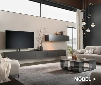 Anthrazitfarbene Wohnwand mit Fernseher in dezent eingerichtetem Wohnzimmer mit Couchtisch und Sofa.