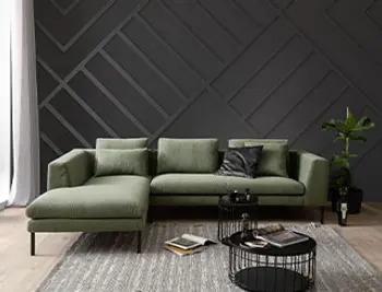 Grünes Boucle Ecksofa mit schwarzen Füßen.