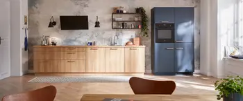 Moderne Küchenzeile mit Küchenschränken aus Holz und blauen Hochschränken mit Holzfronten.