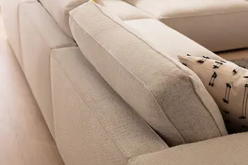 Rückenlehne eines Ecksofas mit beigem Stoffbezug. 
