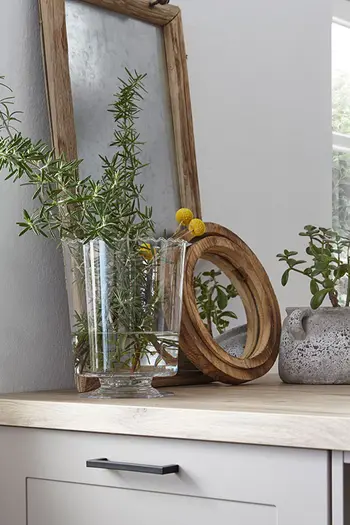 Dekoration mit Rosmarin auf einem Landhausküchenschrank